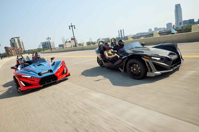 Two vehicles on a highway with a city skyline in the background. 1