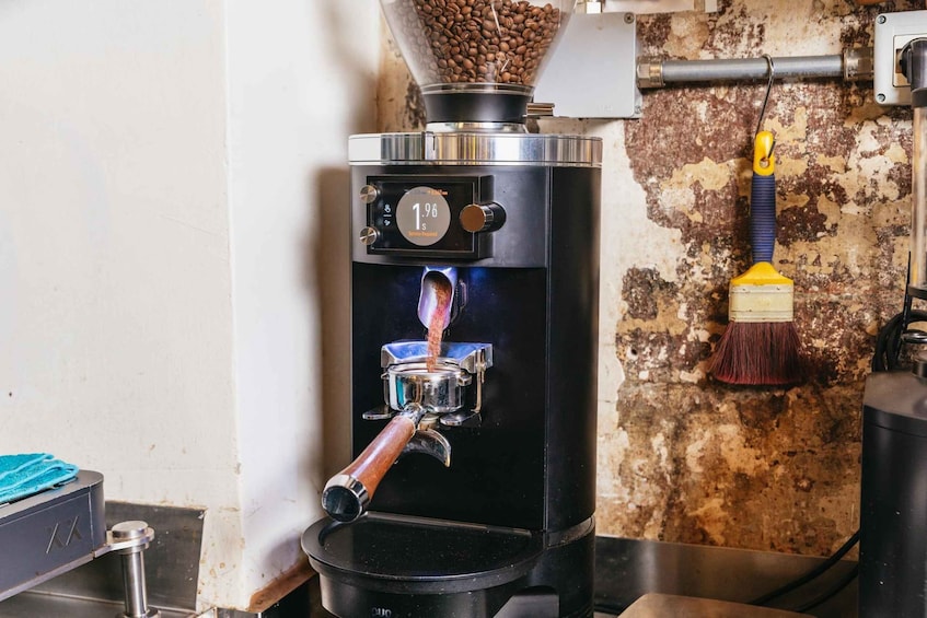 A coffee machine with a digital display, a coffee bean hopper, and a brewing spout. 4