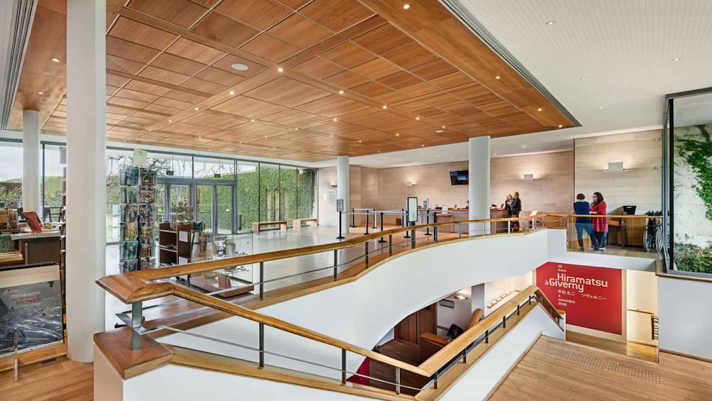 A modern interior with wooden panel ceilings, a glass railing, and a red sign. 4