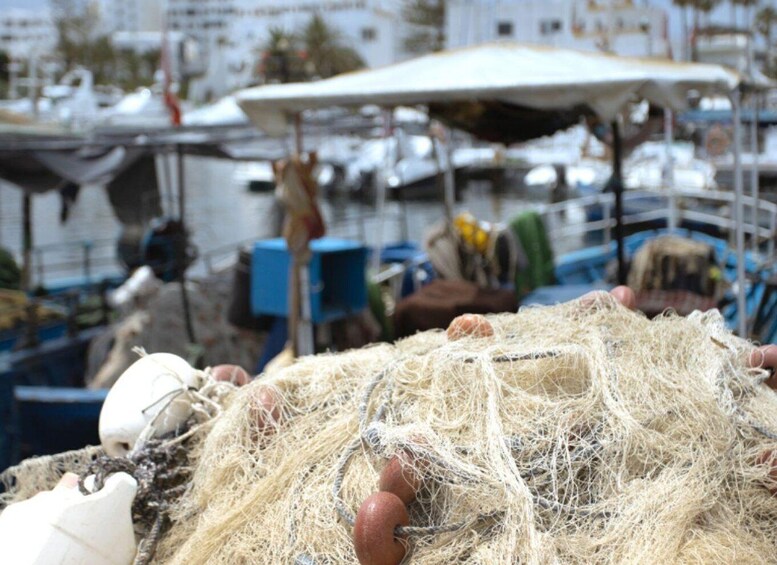 A boat docked at a marina with fishing nets and buoys. 3