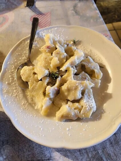 A plate of food with a spoon, on a tablecloth. 2