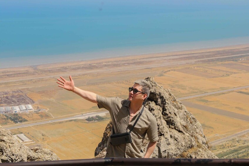 A person standing on a rocky outcrop with a vast landscape in the background. 4