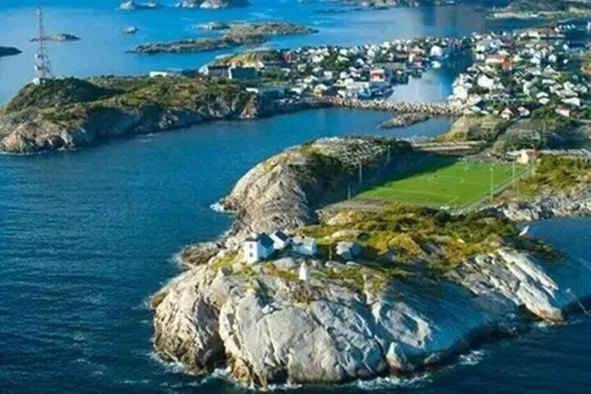 A coastal town with rocky terrain, a lighthouse, and a harbor with boats. 2