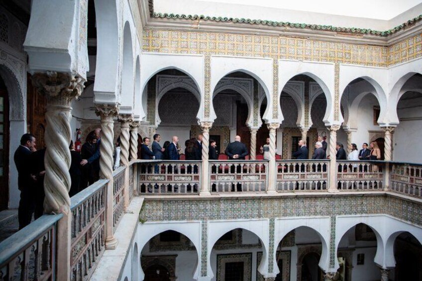 A courtyard with arches, columns, and tiled flooring. 2