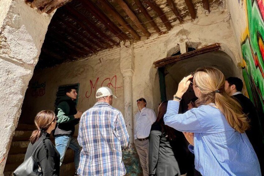 A group of people standing at an entrance with graffiti on the wall. 5