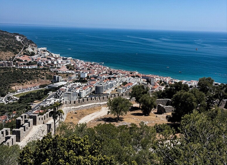 A coastal city with a historic fortification, a dense urban area, and a clear view of the sea. 2
