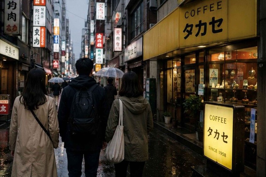 A wet street with people walking, a coffee shop with a sign in Japanese, and various storefronts with signs in Japanese. 2