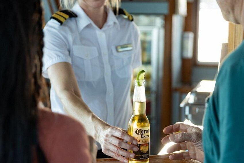 A person handing a bottle of Corona beer to another person. 3