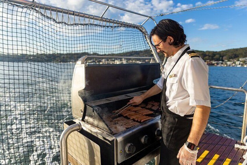 A person grilling meat on a boat with a netted enclosure. 5