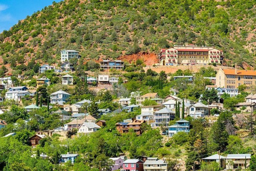 Una zona residencial en una ladera, con casas y un edificio grande en la cima. 2