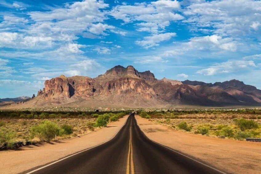 A road leading to a mountain range under a clear sky. 5