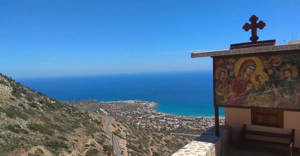 A coastal view with a church featuring a religious mural and a cross. 1