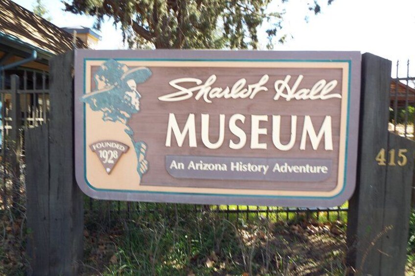 A wooden sign for the Sharlet Hall Museum, featuring a map of Arizona and the museum's founding year. 3