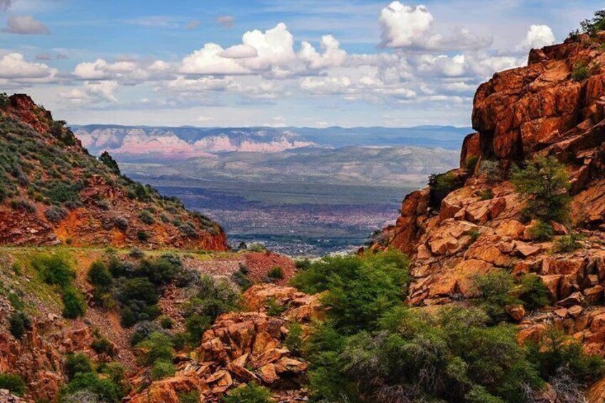 A canyon landscape with rocky cliffs and sparse vegetation. 1