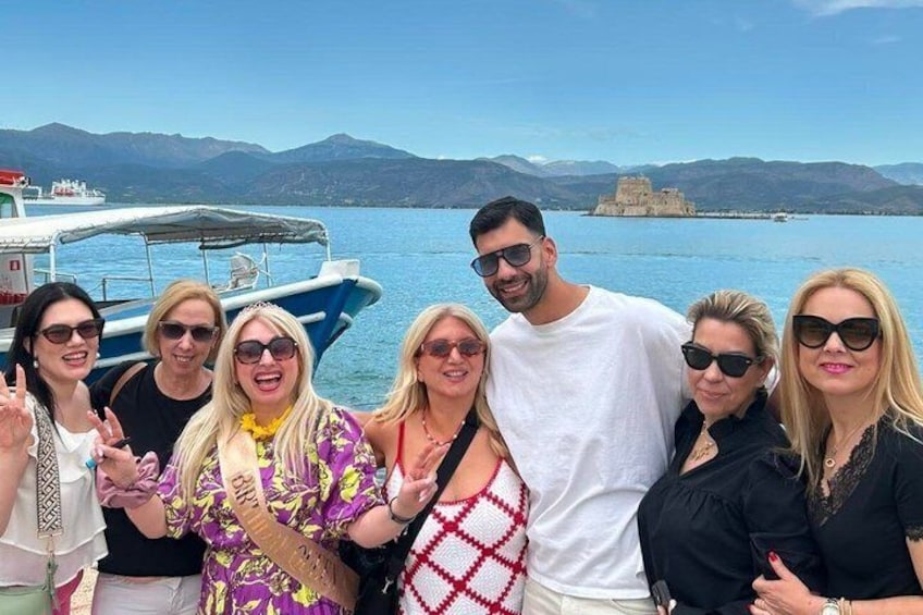 A group of people on a boat with a mountainous landscape and a castle in the background. 2