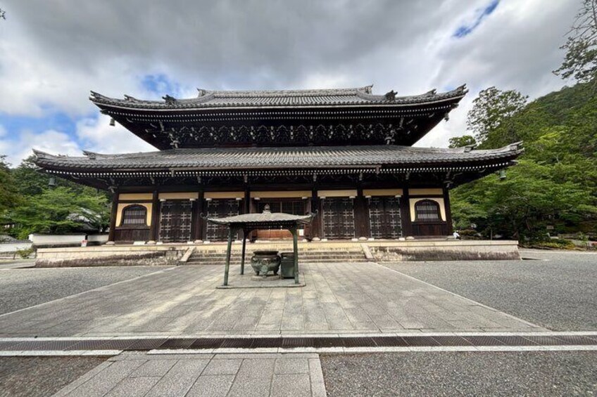 A traditional Japanese building with a tiled roof and a stone pathway leading to it. 4