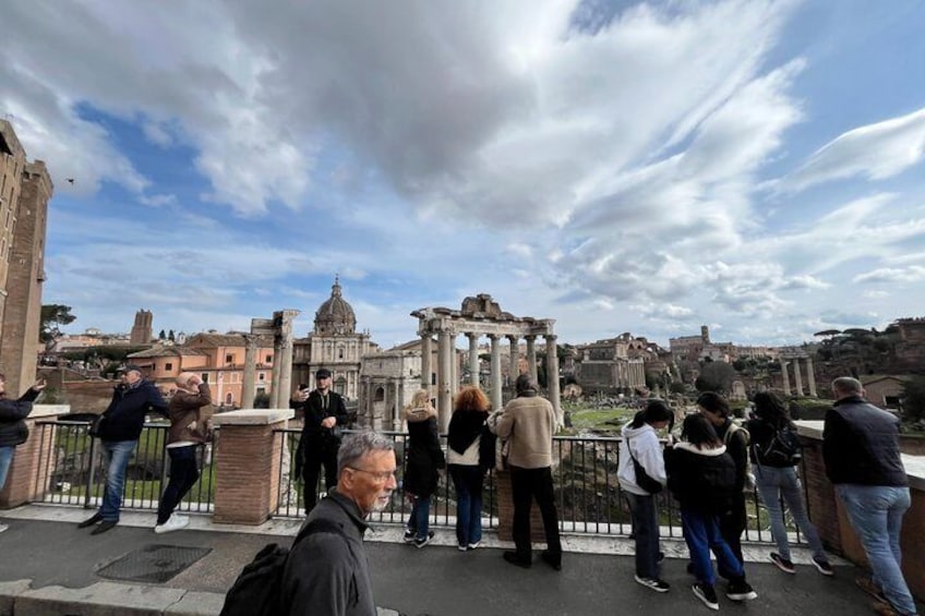 Tourists observing ancient ruins and a large domed building. 5