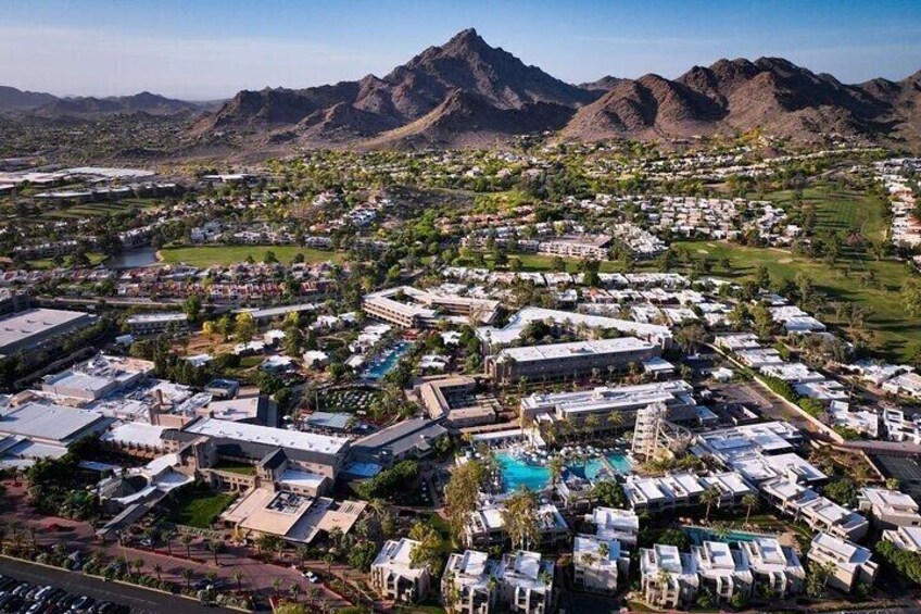 Un quartiere residenziale con case, una piscina e montagne sullo sfondo. 5