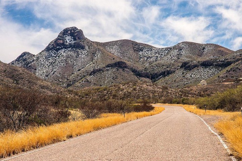 Una carretera atraviesa un paisaje montañoso con vegetación escasa y cielo despejado. 1