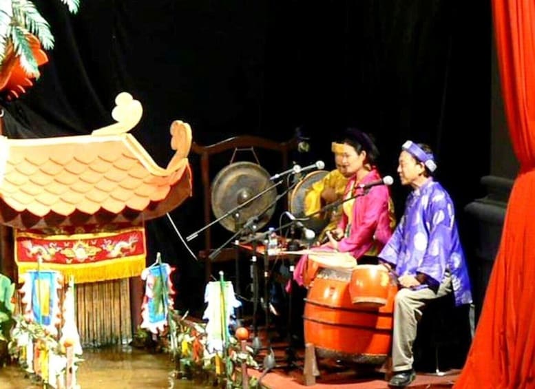 A stage with traditional Chinese architecture, including a dragon and a drum set. 5