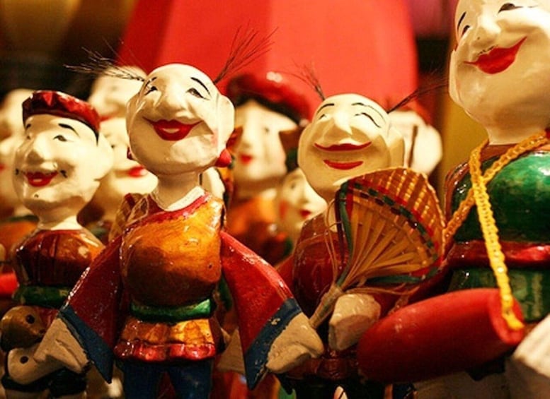 A collection of colorful ceramic figurines, some holding fans, with red and gold accents. 2