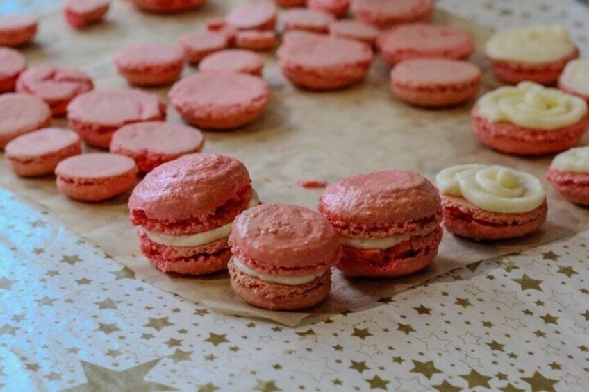 Pink macarons on parchment paper with a star-patterned tablecloth. 2