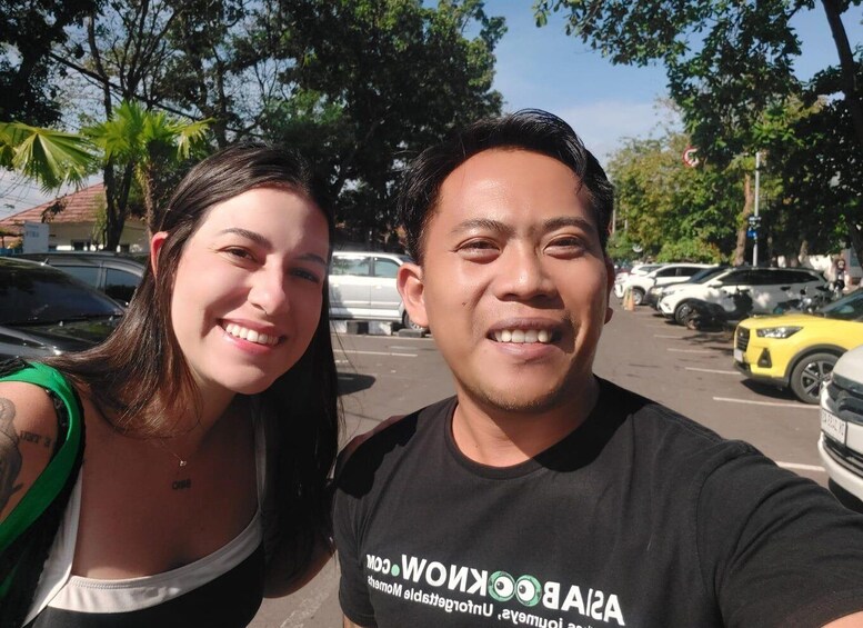Two people in a parking lot with cars and palm trees in the background. 3