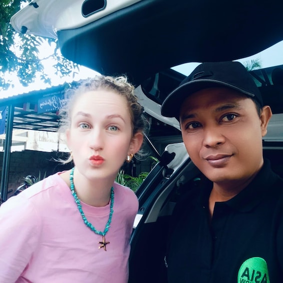 Two people in a car with the trunk open. 2