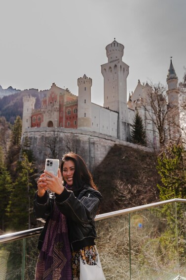 A person taking a selfie with a historic castle in the background. 1