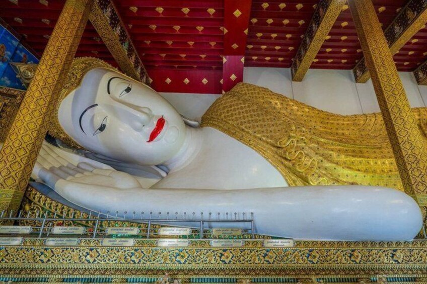 A large reclining Buddha statue with intricate golden patterns and a red roof. 3