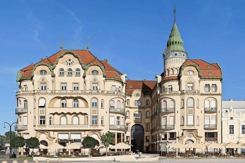 A historic building with ornate architecture, a prominent tower, and a clear blue sky. 3