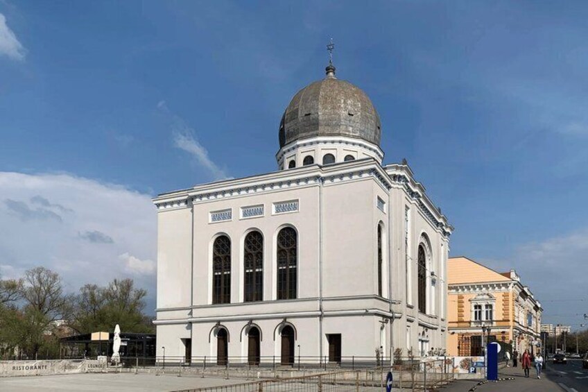 A white building with a dome and arched windows. 2