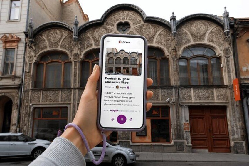 A person holding a smartphone displaying a glassware shop. 1