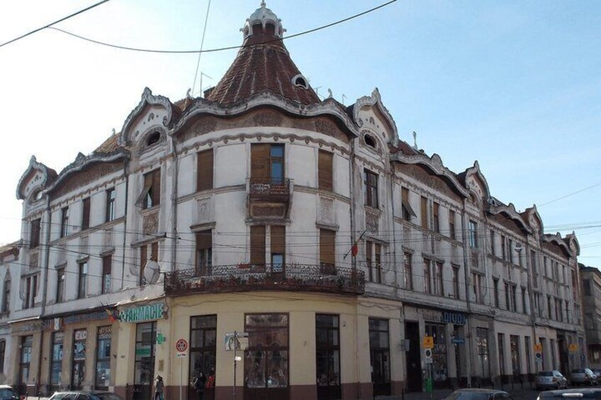 A historic building with ornate architecture, a visible storefront, and a street sign. 4