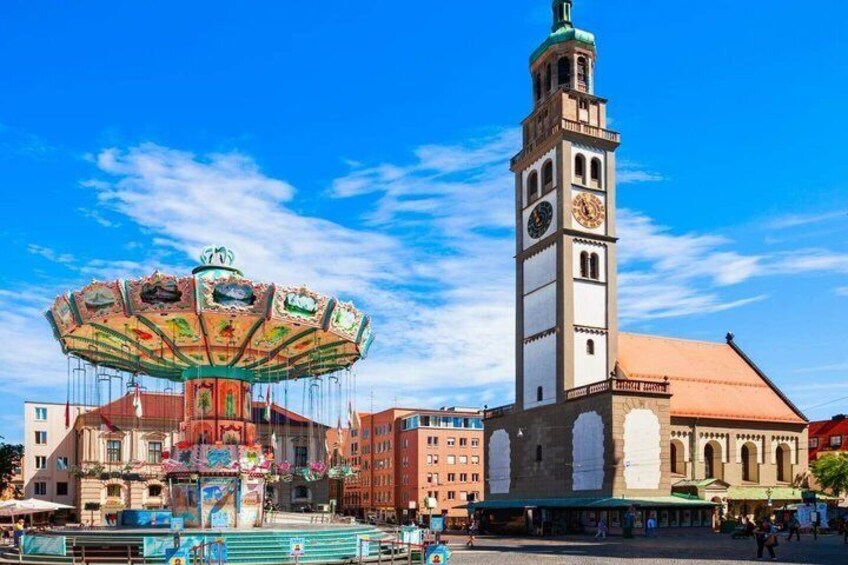 A carousel, a clock tower, and a building with a red roof. 3