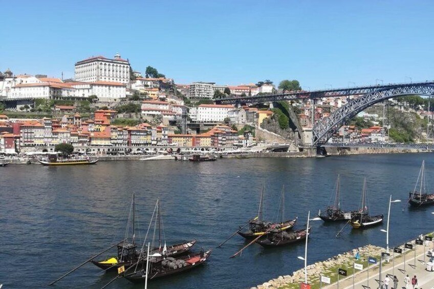A river with boats, a bridge, and buildings along the riverbank. 2