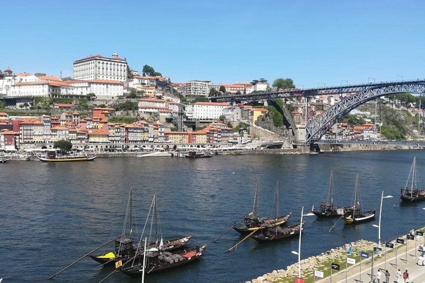 A river with boats, a bridge, and buildings along the riverbank. 2