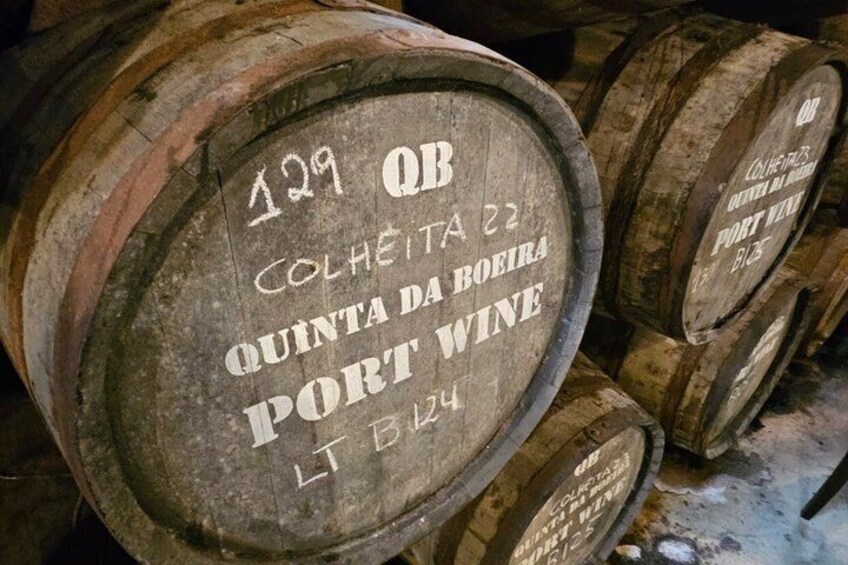 Wooden barrels with inscriptions, likely in a storage or aging facility. 5