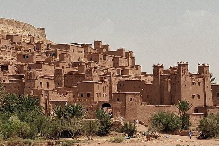 Un pueblo desértico con edificios de adobe y palmeras. 4