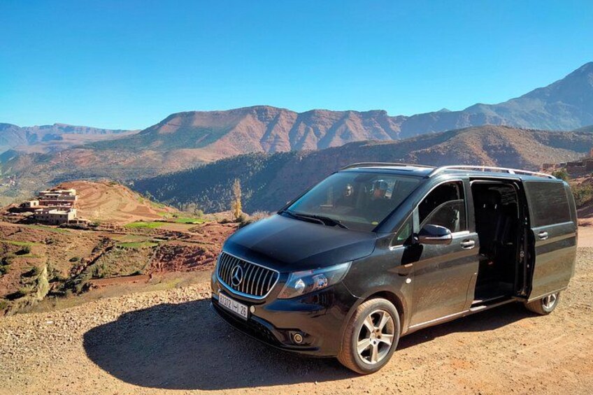 Una camioneta negra estacionada en un camino de tierra con montañas al fondo. 2