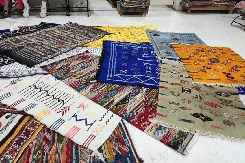 Une variété de tapis colorés, tissés avec différents motifs, étaient disposés sur le sol. 4