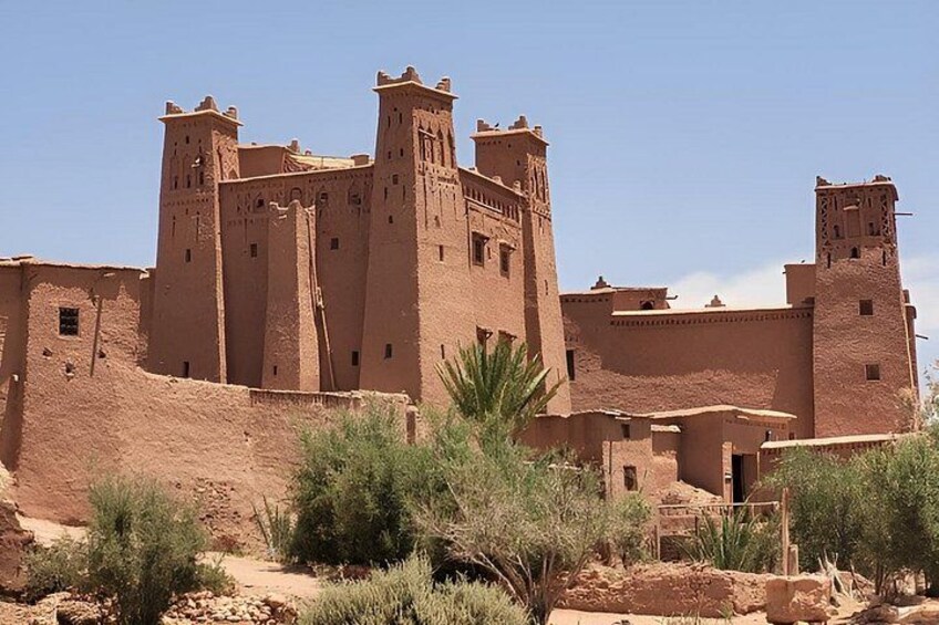 Un gran edificio de adobe con múltiples torres y un paisaje desértico. 5