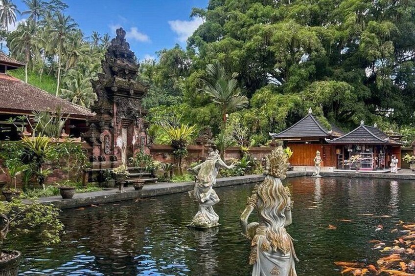 A serene pond with statues, a traditional building, and lush greenery. 4