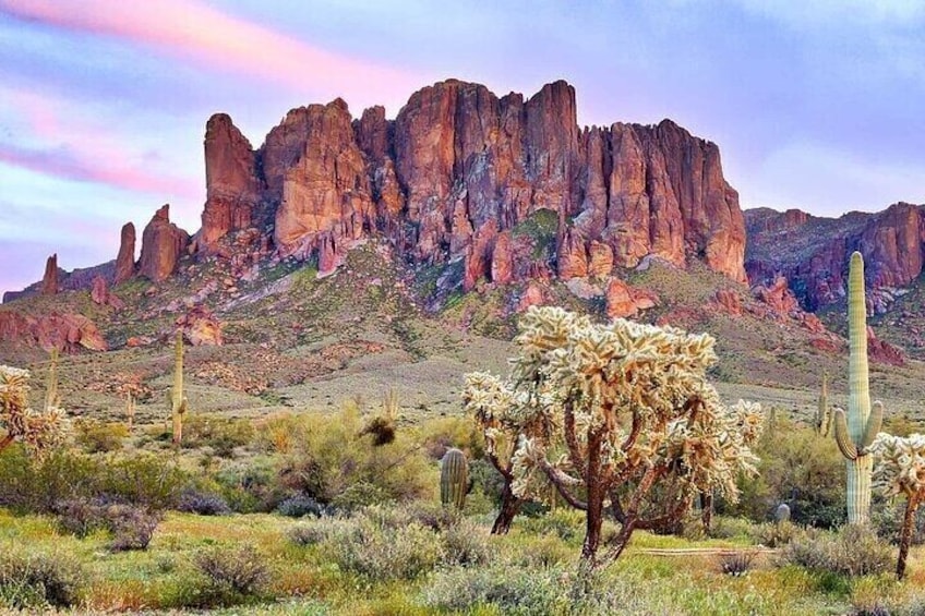 A desert landscape with prominent rock formations, cacti, and sparse vegetation. 5