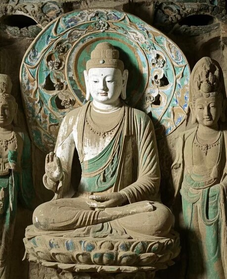 A seated Buddha statue with intricate carvings and a large, ornate backdrop. 2
