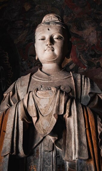 A statue with intricate carvings and a patterned background. 1