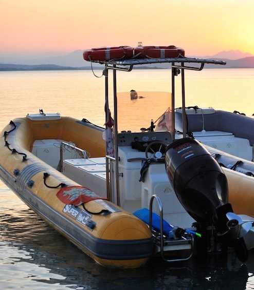 A row of inflatable boats docked at a pier with a sunset in the background. 4