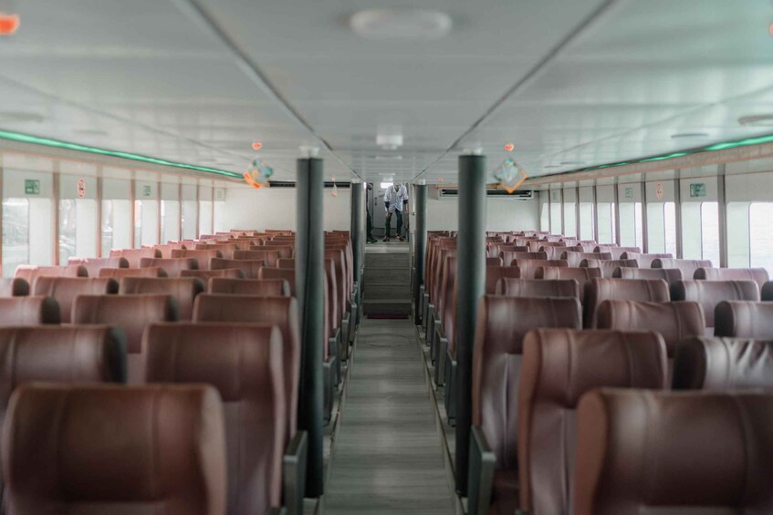 A train interior with rows of brown leather seats and a central aisle. 4