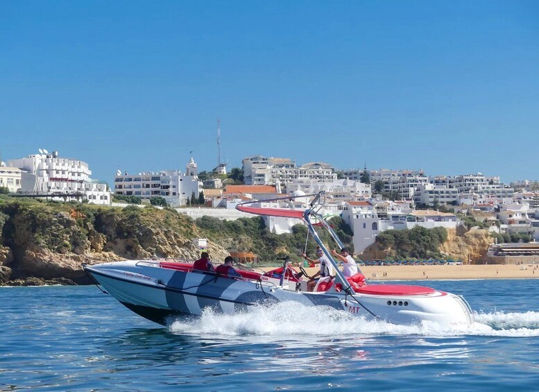 A speedboat with two people on board, moving swiftly through the water. 4