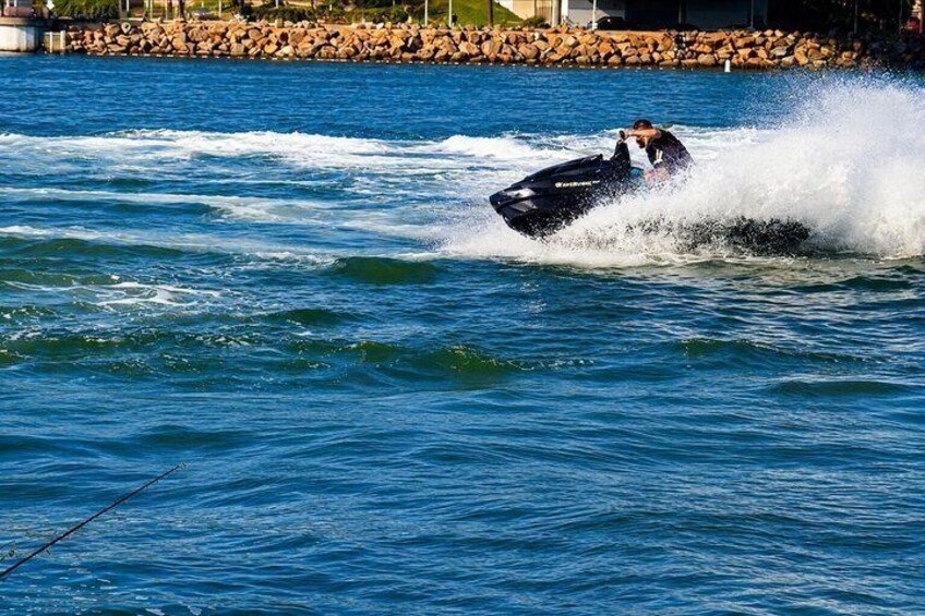 A person jet-skiing on a body of water with waves around them. 2
